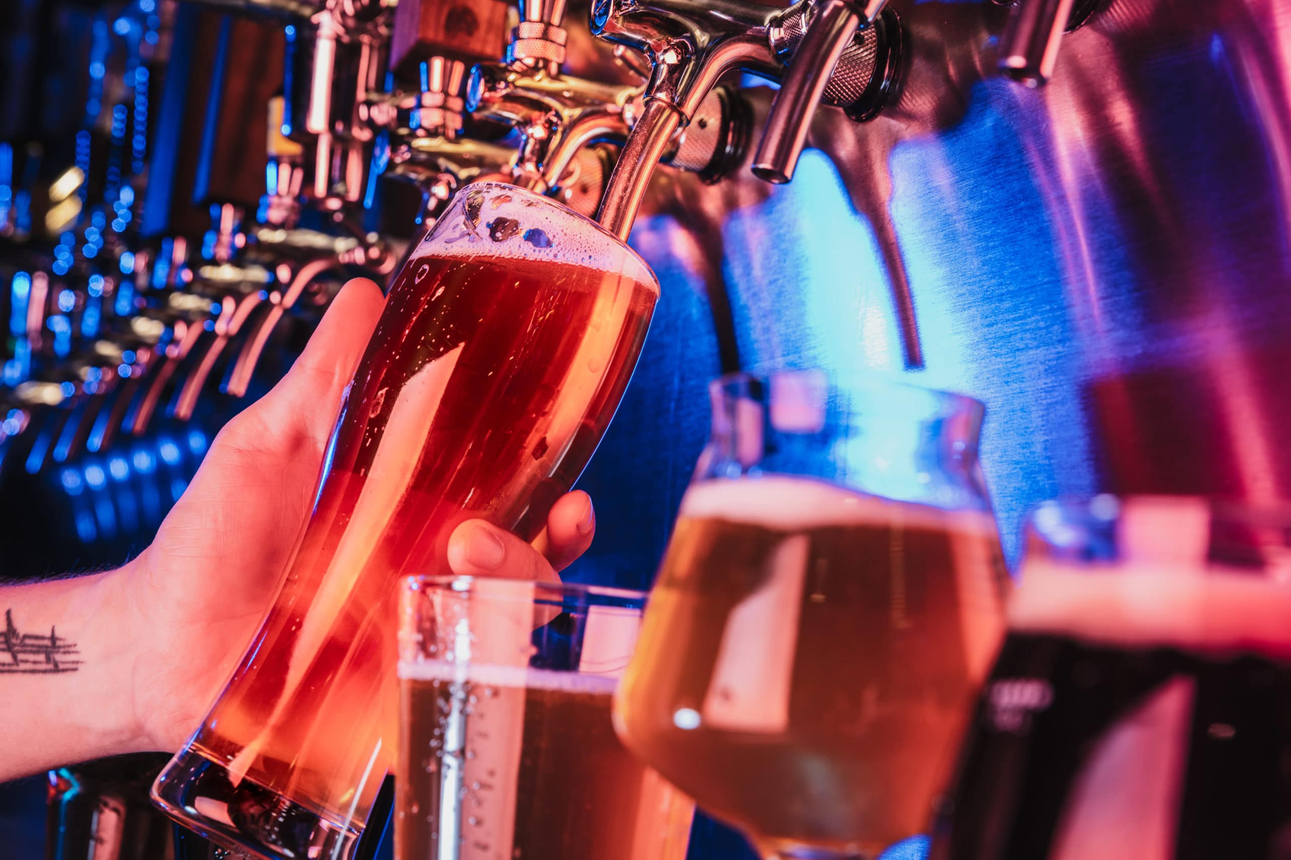 In einer Bar wird ein Bier an einer großen Zapfanlage gezapft.